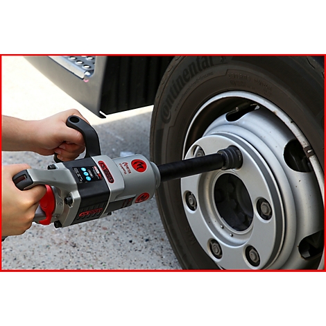 Eine Person verschraubt mit einem Akku-Schlagschrauber ein Rad. Das Werkzeug ist silber-rot, das Rad schwarz-silber.